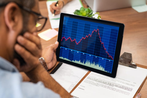 Closeup of a stock market broker working with graphs on digital